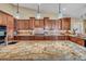 Kitchen island featuring granite countertop, wood cabinets and pendant lights at 8216 W Hammer Ln, Las Vegas, NV 89149