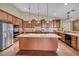 Spacious kitchen features stainless steel appliances, granite countertops, island, and custom wood cabinets at 8216 W Hammer Ln, Las Vegas, NV 89149