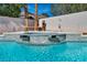 Inviting pool featuring a built-in jacuzzi with stone accents and tranquil waterfalls at 8216 W Hammer Ln, Las Vegas, NV 89149