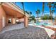 Beautiful covered patio leading to a fenced pool area with palm trees providing shade and privacy at 8216 W Hammer Ln, Las Vegas, NV 89149