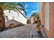 Scenic side yard showcasing desert landscaping with mature palm tree and white exterior stucco wall at 8216 W Hammer Ln, Las Vegas, NV 89149