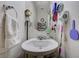 Powder room featuring pedestal sink, decorative mirror and organized amenities at 8783 Halcon Ave, Las Vegas, NV 89148