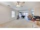 Large, carpeted living room with neutral walls and view of the dining area at 8783 Halcon Ave, Las Vegas, NV 89148