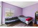 Compact bedroom with purple walls, a futon, and window providing light at 916 Bob Barney Ave, North Las Vegas, NV 89086