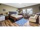 Comfortable bedroom with a cozy rug, wingback chair, and large windows providing ample natural light at 916 Bob Barney Ave, North Las Vegas, NV 89086