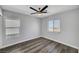 A well-lit bedroom featuring neutral walls, wood floors, and a ceiling fan at 9526 Summer Furnace St, Las Vegas, NV 89178