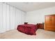 Cozy bedroom featuring a comfortable bed, neutral carpet, and soft, bright light filtering through the large white curtain at 408 N Torrey Pines Dr, Las Vegas, NV 89107