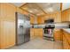 Bright kitchen featuring stainless steel appliances, granite countertops, and wood cabinets at 408 N Torrey Pines Dr, Las Vegas, NV 89107