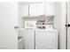 Laundry room equipped with white washer and dryer and storage shelves at 408 N Torrey Pines Dr, Las Vegas, NV 89107