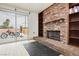 Living room with brick fireplace, built-in shelving, and sliding glass door to backyard at 408 N Torrey Pines Dr, Las Vegas, NV 89107