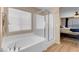 This bathroom has both a walk in shower and a large soaking tub with a tub window at 10135 Haymarket Peak Ave, Las Vegas, NV 89166
