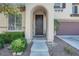 Close-up of the front door entrance with arched porch and manicured landscaping at 10135 Haymarket Peak Ave, Las Vegas, NV 89166