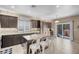 Open kitchen with a large central island with seating and sliding glass doors to the backyard at 10135 Haymarket Peak Ave, Las Vegas, NV 89166