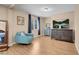 Comfortable living room features a plush chair, tv, and light hardwood flooring at 10135 Haymarket Peak Ave, Las Vegas, NV 89166
