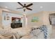 Comfortable living room with neutral colors, a ceiling fan, and a mounted television at 10135 Haymarket Peak Ave, Las Vegas, NV 89166