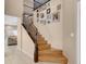 Elegant staircase with wood steps, dark wood railing, and a gallery wall with Gathering photos at 10135 Haymarket Peak Ave, Las Vegas, NV 89166