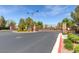 View of the community gate, surrounded by mature trees and landscaping at 10241 Headrick Dr, Las Vegas, NV 89166