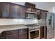 Modern kitchen with stainless steel appliances, dark cabinets, and granite countertops at 10241 Headrick Dr, Las Vegas, NV 89166
