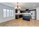 Bright kitchen with stainless steel appliances, dark cabinets, eat-in island, and tiled floors at 10241 Headrick Dr, Las Vegas, NV 89166