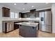 Well-lit kitchen with a central island, stainless appliances, and stone countertops at 10241 Headrick Dr, Las Vegas, NV 89166