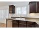 Kitchen featuring dark wood cabinets, granite counters, stainless steel dishwasher and natural light at 10241 Headrick Dr, Las Vegas, NV 89166