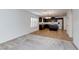 Open-concept living space with carpeted living room flows into tiled kitchen and dining area at 10241 Headrick Dr, Las Vegas, NV 89166