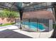 Backyard pool enclosed by a mesh safety fence, surrounded by concrete patio at 10241 Headrick Dr, Las Vegas, NV 89166