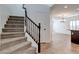 Carpeted staircase with dark wood railing and tiled landing, leading to upper level and living area at 10241 Headrick Dr, Las Vegas, NV 89166
