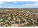Aerial view of a large community with houses, streets, and a school under a sunny sky at 10281 Wolves Den Ln, Las Vegas, NV 89178