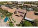 Aerial view of a home's backyard with a patio, pool, manicured landscaping, and trees for privacy at 10281 Wolves Den Ln, Las Vegas, NV 89178