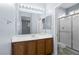 Bathroom features a vanity, large mirror, and glass shower at 10281 Wolves Den Ln, Las Vegas, NV 89178