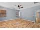 Spacious bedroom with hardwood floors, ceiling fan, two windows, and view to the hallway at 10281 Wolves Den Ln, Las Vegas, NV 89178