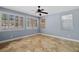Bright bedroom with tiled floors, ceiling fan, and large shuttered windows at 10281 Wolves Den Ln, Las Vegas, NV 89178