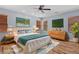 Serene bedroom featuring warm wood floors, a ceiling fan, and bright windows at 10281 Wolves Den Ln, Las Vegas, NV 89178