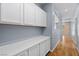 Bright hallway featuring hardwood floors, storage cabinets, and open view to the second floor at 10281 Wolves Den Ln, Las Vegas, NV 89178
