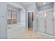 Bright main bathroom with a soaking tub and separate shower, featuring tile flooring at 10281 Wolves Den Ln, Las Vegas, NV 89178