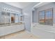 Bright main bathroom featuring a large soaking tub, granite countertops and tile floors at 10281 Wolves Den Ln, Las Vegas, NV 89178