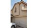 Beige two-story home featuring a two-car garage, balcony and desert landscaping at 10282 Keystone Pastures St, Las Vegas, NV 89183