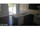 The open concept kitchen has black cabinets, a view of the patio, and white appliances at 10282 Keystone Pastures St, Las Vegas, NV 89183