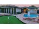 Picturesque backyard with a pool, putting green, stone patio, and the home's exterior at 10309 Canyon Valley Ave, Las Vegas, NV 89145