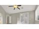 This bedroom features a ceiling fan, double doors to the outside, and a window at 10309 Canyon Valley Ave, Las Vegas, NV 89145