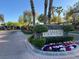 This community entrance boasts a beautiful stone sign, palm trees, and colorful flower beds at 10309 Canyon Valley Ave, Las Vegas, NV 89145