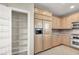Kitchen boasting wood cabinets, stainless steel appliances, and an open pantry at 10309 Canyon Valley Ave, Las Vegas, NV 89145
