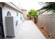 A long, narrow, private backyard with pavers, small desert trees, and a block wall at 128 Golf Course St, Las Vegas, NV 89145