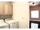 Functional laundry room with washer, dryer, and adjacent room with tile floors at 128 Golf Course St, Las Vegas, NV 89145