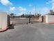 View of a gated entrance to a quiet, well-maintained neighborhood with mature trees and tidy landscaping at 1405 S Nellis Blvd # 2087, Las Vegas, NV 89104