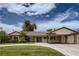 Inviting single-story home with a covered carport, manicured lawn, and circular driveway at 1712 Chapman Dr, Las Vegas, NV 89104