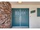 Charming front entrance with a vibrant teal door and brick accents at 1712 Chapman Dr, Las Vegas, NV 89104