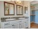 Bright bathroom with double sinks, granite countertop, and a walk-in closet at 1800 Summit Pointe Dr, Las Vegas, NV 89117