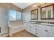 Bathroom featuring a soaking tub, stand up shower, and double sink vanity with granite counters at 1800 Summit Pointe Dr, Las Vegas, NV 89117
